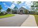 Exterior of a clubhouse with a teal roof, portico entryway, and a well-manicured circular drive at 8703 Bardmoor Blvd # 304, Seminole, FL 33777