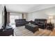 Open living area features leather sofas and sliding glass door to balcony at 8703 Bardmoor Blvd # 304, Seminole, FL 33777