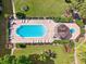 Aerial view of a community pool, surrounded by lush landscaping, sun loungers, and outdoor amenities at 8703 Bardmoor Blvd # 304, Seminole, FL 33777