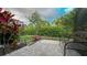 Landscaped backyard featuring a paver patio, lush lawn, and tropical plants, creating a serene outdoor oasis at 8732 Rain Song Rd, Sarasota, FL 34238