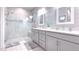 Bright, modern bathroom with double vanity, granite countertop, and a glass-enclosed shower at 8732 Rain Song Rd, Sarasota, FL 34238