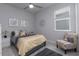 Cozy bedroom with a gray bed, bright pillows, side tables, window, and decor at 8732 Rain Song Rd, Sarasota, FL 34238