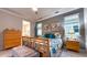 Well-lit bedroom boasts modern furniture, with a view into an ensuite bathroom at 8732 Rain Song Rd, Sarasota, FL 34238