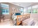 Comfortable bedroom features stylish decor, two windows and an upholstered bench at 8732 Rain Song Rd, Sarasota, FL 34238