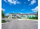 Stately exterior of the clubhouse with a porte cochere, manicured landscaping, and architectural details at 8732 Rain Song Rd, Sarasota, FL 34238