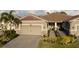 Charming home featuring a brick-paved driveway, two-car garage, manicured landscaping, and a welcoming entrance at 8732 Rain Song Rd, Sarasota, FL 34238