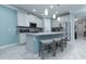 Bright kitchen with island, stainless appliances, gray cabinets, and tiled floors at 8732 Rain Song Rd, Sarasota, FL 34238