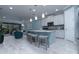 Modern kitchen featuring white cabinets, an island with bar seating, and an open layout to the living area at 8732 Rain Song Rd, Sarasota, FL 34238