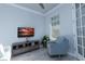 Bright and cozy room featuring a comfortable armchair, modern TV console, and neutral decor at 8732 Rain Song Rd, Sarasota, FL 34238