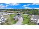 Expansive aerial view of a modern home with a three-car garage, complemented by a lush, fenced backyard and neighborhood at 9843 Cabernet Ave, Seffner, FL 33584