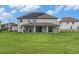 The expansive backyard features lush green grass, a covered patio, and a fence creating the perfect place to entertain at 9843 Cabernet Ave, Seffner, FL 33584
