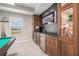 Stylish home bar featuring wood cabinets, granite countertop, stainless steel beverage cooler, and custom backsplash at 9843 Cabernet Ave, Seffner, FL 33584