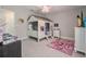 Whimsical bedroom features a cozy house-themed bed, pink ceiling fan and carpeted flooring at 9843 Cabernet Ave, Seffner, FL 33584