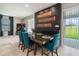 Modern dining room with unique decor, sleek table setting, and stylish blue upholstered chairs at 9843 Cabernet Ave, Seffner, FL 33584