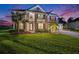 Beautifully lit two-story home featuring decorative lighting, a well-maintained lawn, and a paved driveway at 9843 Cabernet Ave, Seffner, FL 33584