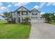Stunning two-story home features a three-car garage, lush landscaping, and a beautifully paved driveway at 9843 Cabernet Ave, Seffner, FL 33584
