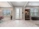 Bright foyer features decorative glass front door and side-lights, herringbone floors, and views to adjacent living spaces at 9843 Cabernet Ave, Seffner, FL 33584
