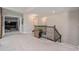 Upstairs landing game room featuring a stand up arcade machine, wrought iron railing, and neutral carpet at 9843 Cabernet Ave, Seffner, FL 33584
