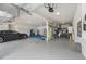 Spacious three-car garage with epoxy flooring, ample storage, an EV charger, and a car at 9843 Cabernet Ave, Seffner, FL 33584