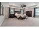Large main bedroom with tray ceiling, dark wood furniture, carpet floors, and custom window treatments at 9843 Cabernet Ave, Seffner, FL 33584