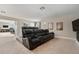 Media room featuring tiered leather seating, neutral carpeting, and an adjacent game room through an open doorway at 9843 Cabernet Ave, Seffner, FL 33584