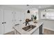 Well-lit kitchen island with stainless steel sink, white cabinets, and modern appliances in an open-concept space at 100 4Th S Ave # 132, St Petersburg, FL 33701