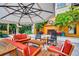 Inviting outdoor lounge area with comfortable seating, umbrella, and charming fireplace feature at 100 4Th S Ave # 132, St Petersburg, FL 33701