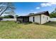 Backyard featuring a screened porch, complemented by lush landscaping and a secure white fence at 10717 Drummond Rd, Tampa, FL 33615