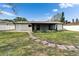 Well-maintained backyard features a stone pathway leading to a screened porch, surrounded by a white privacy fence at 10717 Drummond Rd, Tampa, FL 33615