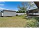 Spacious backyard featuring a shed, screened porch, complemented by lush landscaping and a secure white fence at 10717 Drummond Rd, Tampa, FL 33615
