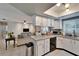 Bright, efficient kitchen featuring stainless appliances and white cabinetry with a passthrough to the living room at 10717 Drummond Rd, Tampa, FL 33615