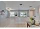 Bright living room with neutral paint, tile flooring, and sunlit windows with decorative curtains at 10717 Drummond Rd, Tampa, FL 33615
