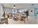 Inviting living room showcasing an open floor plan and a modern kitchen with seamless flow, tile floors, and neutral tones at 10717 Drummond Rd, Tampa, FL 33615