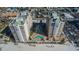 Aerial view of luxurious condos overlooking a unique, kidney-shaped community pool and beach access at 11 San Marco St # 407, Clearwater Beach, FL 33767