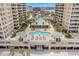 Overhead view of a beachfront condo with a pool, palm trees, and manicured landscaping at 11 San Marco St # 407, Clearwater Beach, FL 33767