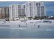 Beachfront view of condo buildings with people enjoying the beach at 11 San Marco St # 407, Clearwater Beach, FL 33767