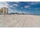 Scenic beach view with soft sand and beachfront condos and hotels in the distance at 11 San Marco St # 407, Clearwater Beach, FL 33767