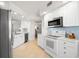 A modern kitchen with stainless steel appliances, sleek white cabinetry, and a bright backsplash offers a clean and functional space at 11 San Marco St # 407, Clearwater Beach, FL 33767