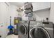 This laundry room features a newer washer and dryer, utility sink, and storage shelving at 11 San Marco St # 407, Clearwater Beach, FL 33767