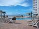 Relaxing pool area with lounge chairs and views of the ocean and beachfront condo building at 11 San Marco St # 407, Clearwater Beach, FL 33767