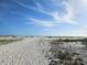 Beach view with sandy dunes and clear blue sky, showcasing the natural beauty of the area at 126 119Th Ave, Treasure Island, FL 33706