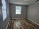 Bedroom featuring wood-look floors, natural light from two windows, and neutral gray walls at 126 119Th Ave, Treasure Island, FL 33706
