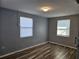 Bedroom featuring wood-look floors, natural light from two windows, and neutral gray walls at 126 119Th Ave, Treasure Island, FL 33706
