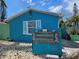 Charming beach house features a vibrant blue exterior and unique address signage at 126 119Th Ave, Treasure Island, FL 33706
