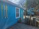 Charming home with a wooden deck, vibrant blue exterior, and coastal decor at 126 119Th Ave, Treasure Island, FL 33706