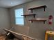 Room featuring wood-look floors, natural light from a window, and convenient floating shelves at 126 119Th Ave, Treasure Island, FL 33706