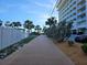 Exterior walking path next to high rise building with palm trees and green landscaping at 126 119Th Ave, Treasure Island, FL 33706