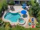 Aerial view showcasing a pool with a connected spa and a spacious patio at 13302 Trailing Moss Dr, Dade City, FL 33525