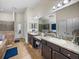 This bathroom includes a double vanity, granite countertops, and tiled floors at 13302 Trailing Moss Dr, Dade City, FL 33525