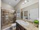 Bathroom featuring a granite countertop, stylish sink, and a tile shower with a glass door at 13302 Trailing Moss Dr, Dade City, FL 33525